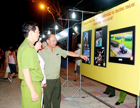 Thiếu tướng Lê Văn Út- Giám đốc Công an tỉnh Vĩnh Long xem những bức ảnh đạt giải cao của cuộc thi. Ảnh: DƯƠNG THU