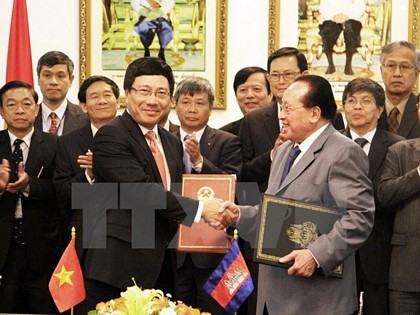 Phó Thủ tướng Phạm Bình Minh (trái) trao đổi Biên bản Thỏa thuận của Kỳ họp thứ 13 với Phó Thủ tướng Campuchia Hor Namhong. (Ảnh: Xuân Khu/TTXVN)
