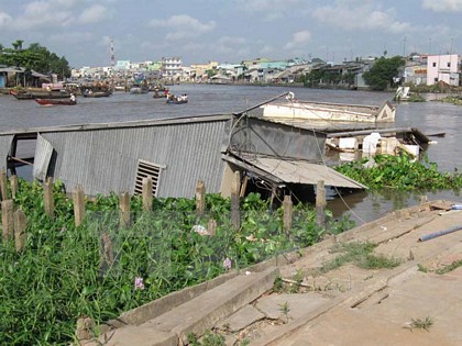 Bờ sông Cần Thơ đoạn qua ấp Nhơn Lộc 1, thị trấn Phong Điền, bị sạt lở dài kéo theo 4 căn nhà đổ xuống sông. (Ảnh: Trần Khánh Linh/TTXVN)