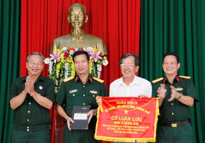 Đại tá Phạm Văn Bé Tư- Chính ủy Bộ CHQS tỉnh Vĩnh Long (bên phải) trao cờ luân lưu và sổ đăng cai hội nghị năm 2016 cho tỉnh Kiên Giang.