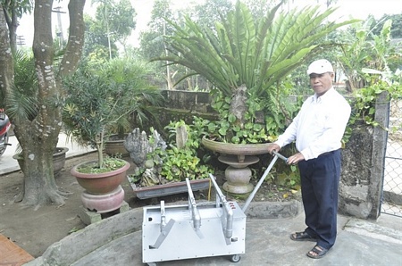 Ông Nguyễn Văn Hồng với chiếc máy cắt tỉa cây cảnh.