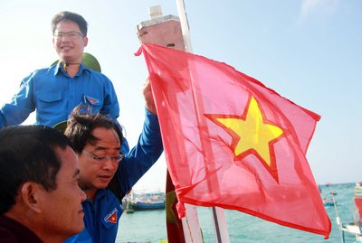  Bí thư đoàn khối các cơ quan tỉnh Vĩnh Long Lưu Minh Tiến tặng và treo cờ cùng ngư dân Phú Quý.