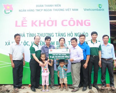 Đại diện Vietcombank trao tặng kinh phí hỗ trợ nhà cho anh Thắng.