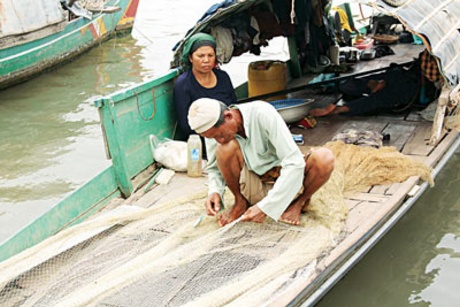 Ông Kharim, một người dân Campuchia kiểm tra lại chài trước khi đi “kiếm cơm” ở Seam Reap