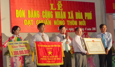 Ông Trần Văn Rón- Ủy viên BCH Trung ương Đảng, Bí thư Tỉnh ủy, Trưởng BCĐ xây dựng NTM tỉnh trao bằng công nhận xã đạt chuẩn NTM cùng các phần thưởng cho xã Hòa Phú.