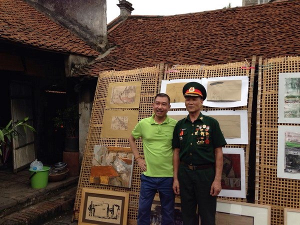    Họa sĩ Lê Thiết Cương chụp cùng Chủ tịch Hội Cựu chiến binh thôn Cự Đà. (Ảnh: Đăng Hữu/Vietnam+)