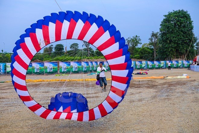 Một nghệ nhân diều từ Malaysia đang cố gắng nâng con diều mang cờ Malaysia lên không trung. (Ảnh: PV/Vietnam+)