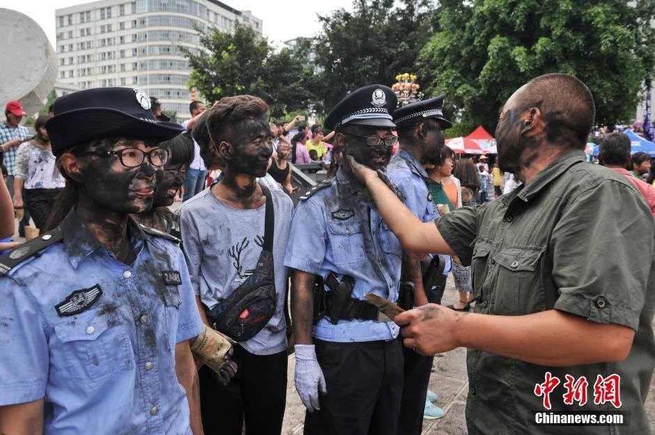 Đội cảnh sát ở một khu tự trị thuộc tỉnh Vân Nam (Trung Quốc) đã bị người dân bắt đứng yên để bôi mực đen lên mặt. Mặc dù bị bôi đen khắp mặt nhưng những cảnh sát này vẫn cười tươi. (Nguồn: CCTVNews)