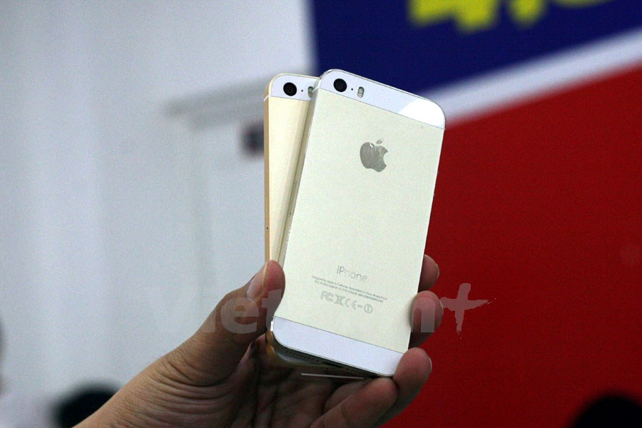 Cùng một màu vàng đồng, song iPhone SE (phía dưới) trông đậm màu hơn iPhone 5S. (Ảnh: Trung Hiền/Vietnam+)