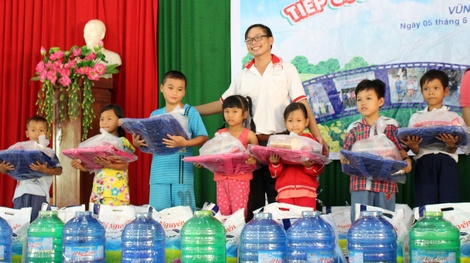 Đại diện Hội từ thiện Cà phê Suối Mơ TP Vĩnh Long trao quà cho các em học sinh.