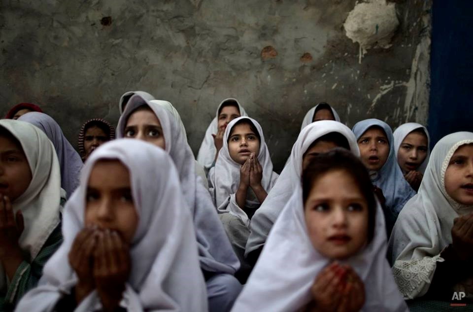 Các bé gái Pakistan đang cầu nguyện cho 5 giáo viên và 2 nhân viên cứu trợ bị bắn chết ngày 14/6. Các em thuộc nhiều bộ lạc khác nhau ở Pakistan buộc phải dời đi do xung đột giữa các lực lượng nổi dậy. (Nguồn: AP)