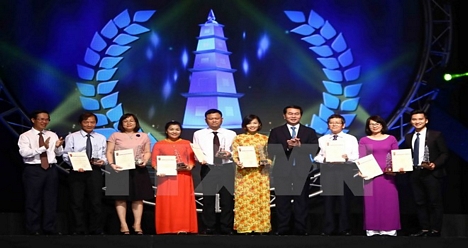 Chủ tịch nước Trần Đại Quang và ông Võ Văn Thưởng, Ủy viên Bộ Chính trị, Trưởng Ban Tuyên giáo Trung ương trao giải A cho các tác giả đoạt giải. (Ảnh: Minh Quyết/TTXVN)