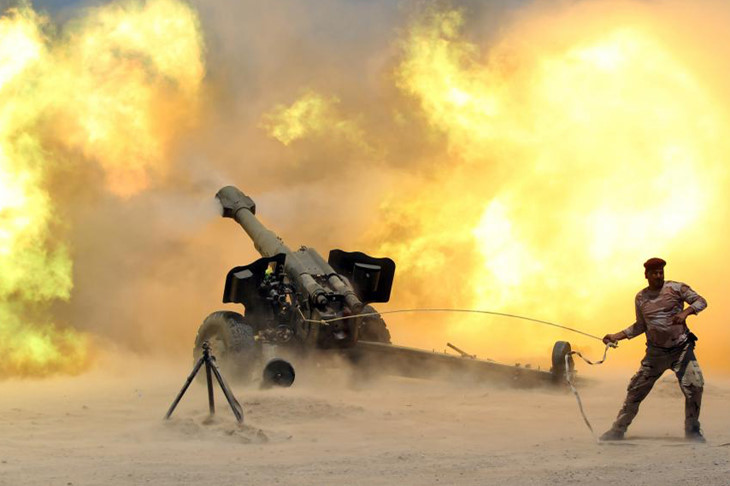 Một binh sĩ Iraq giật cò khẩu pháo nhả đạn vào vị trí của IS.