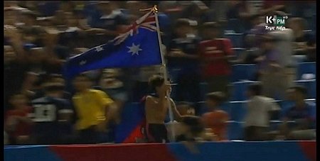 Một CĐV Campuchia vừa chạy vừa cầm quốc kì của Australia trên khán đài trong trận chung kết