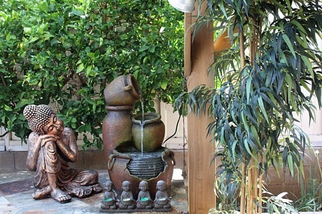 Góc vườn bình yên nhà Thu Phương với bức tượng phật gối đầu thư thái.
