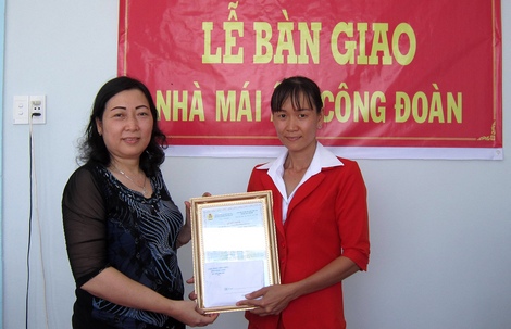 Bà Lê Thị Kim Hoa (trái)- UVTV, Trưởng Ban Chính sách pháp luật LĐLĐ tỉnh trao quyết định bàn giao nhà cho chị Thảo.