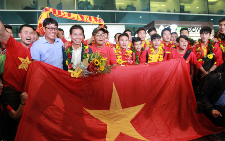 Thầy trò HLV Hoàng Anh Tuấn chụp ảnh lưu niệm với CĐV tại sân bay.