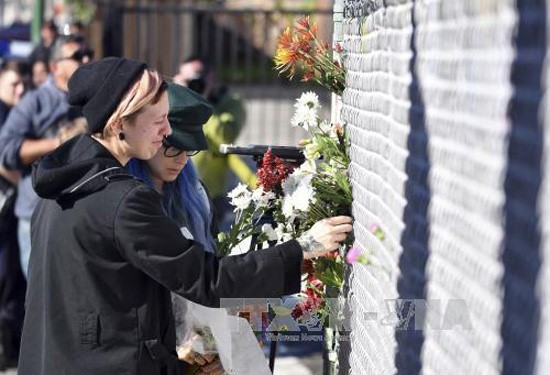 Đặt hoa tưởng niệm các nạn nhân sau vụ hỏa hoạn. Ảnh: AP/TTXVN