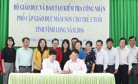 Ông Nguyễn Bá Ninh và ông Lữ Quang Ngời ký biên bản kiểm tra kết quả phổ cập giáo dục mầm non cho trẻ 5 tuổi.
