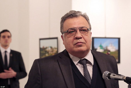 Đại sứ Nga tại Thổ Nhĩ Kỳ, Andrey Karlov, đến khai mạc một triển lãm ảnh của Nga ở Ankara. Người thanh niên phía sau là hung thủ chuẩn bị ám sát ông. Ảnh: AP.