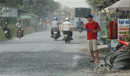 Người dân cho biết không còn cách nào khác phải tưới nước lên mặt đường để hạn chế bụi.