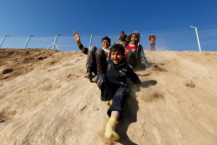 Bức tường đất cao bao quanh bảo vệ trại Khazer cũng có thể trở thành cầu trượt cho các em.