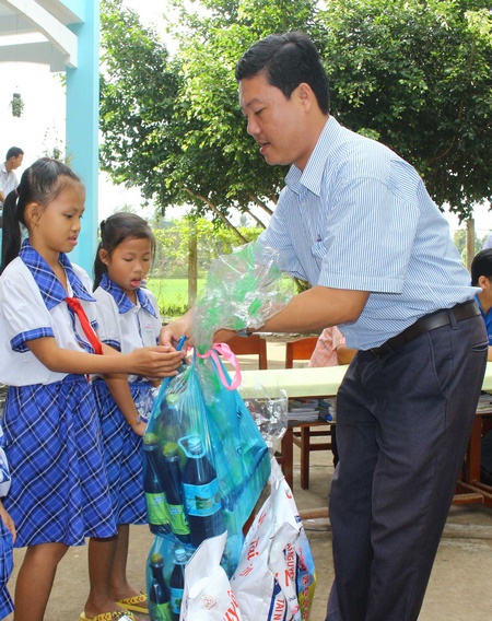 Bí thư Đảng ủy xã Bình Phước Ngô Hùng Nhân tặng quà cho học sinh nghèo.