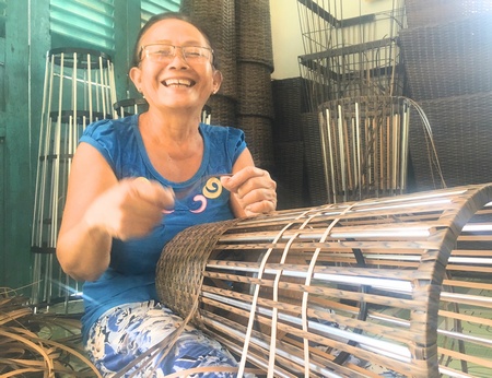 Cô Hành Thị Sển cười tươi với nghề đan thủ công.