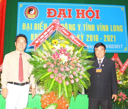 Phó Chủ tịch UBND tỉnh- Lữ Quang Ngời (bìa trái) trao lẳng hoa của Tỉnh ủy, HĐND, UBMTTQ Việt Nam tỉnh Vĩnh Long chúc mừng đại hội.
