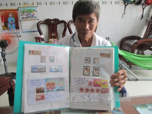 Ông Trần Hữu Huệ bên bộ sưu tập tem với chuyên đề: “Thế giới công nhận Hoàng Sa - Trường Sa là của Việt Nam qua con tem bưu chính” sắp hoàn thành.