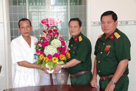 Đại tá Phạm Văn Bé Tư- Chính ủy Bộ Chỉ huy Quân sự tỉnh tặng hoa chúc mừng tại Bệnh xá Quân y.