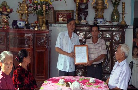 AÔng Lê Ngọc Đức- Phó Chủ tịch UBND huyện Tam Bình (trái) trao quyết định bàn giao nhà tình nghĩa.