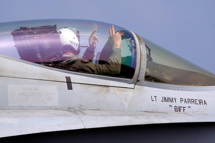 Một phi công F18 ra hiệu bằng tay cho lực lượng trên boong trước khi máy bay của anh này cất cánh.