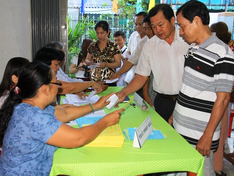 Người dân làm các thủ tục nhận phiếu bầu tại các điểm bầu cử.  