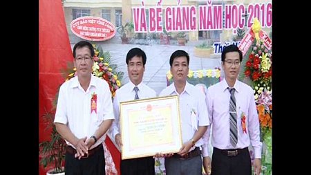 Ông Nguyễn Thanh Triều- Tỉnh ủy viên, Bí thư Huyện ủy Trà Ôn (bìa trái) trao bằng công nhận cho Ban giám hiệu.