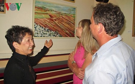 Họa sĩ Hoàng Tuyết Hạnh giới thiệu tranh cho khách tham quan triển lãm.