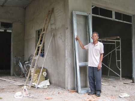 Ông Nguyễn Văn Đạn bên căn nhà cất dang dở.