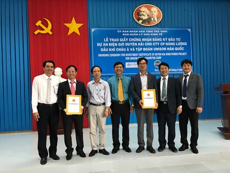 Ông Phạm Văn Tám (thứ 4 từ trái sang)- Trưởng Ban Quản lý Khu kinh tế tỉnh Trà Vinh trao giấy chứng nhận cho nhà đầu tư Dự án Nhà máy Điện gió Duyên Hải.