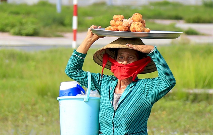 Mâm bánh cam là nguồn mưu sinh chính của người phụ nữ này. Từ sáng, đến chiều chị đều đi rảo khắp các tuyến phố để bán bánh.