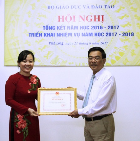 Phó Chủ tịch UBND tỉnh- Trần Hoàng Tựu trao bằng khen của Bộ GD- ĐT  cho đại diện lãnh đạo Sở GD- ĐT Vĩnh Long. 