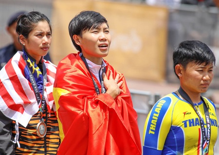 Tay đua Nguyễn Thị Thật tự hào khoác lên mình quốc kỳ Việt Nam trong lễ trao giải đua xe đạp vòng tròn nữ. Ảnh: ĐỨC HUY