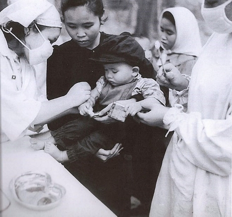 Chiến sỹ quân y tình nguyện Việt Nam phòng chống dịch bệnh trong vùng giải phóng Lào năm 1962. (Nguồn: Sách ảnh Quan hệ đặc biệt Việt Nam-Lào/Nhà xuất bản Thông tấn)