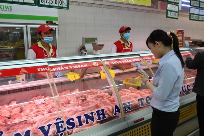 Người tiêu dùng chọn lựa sản phẩm thịt heo có truy xuất nguồn gốc tại hệ thống siêu thị Co.op mart. (Ảnh: Thanh Vũ/TTXVN)
