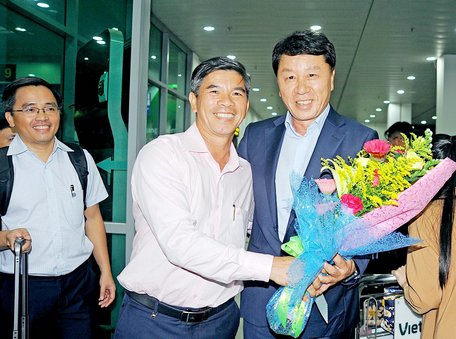 Ông Huỳnh Mau bắt tay, tặng hoa cho vị GĐKT Chung Hae Seong ngay khi xuống sân bay. Ảnh: MINH VỸ