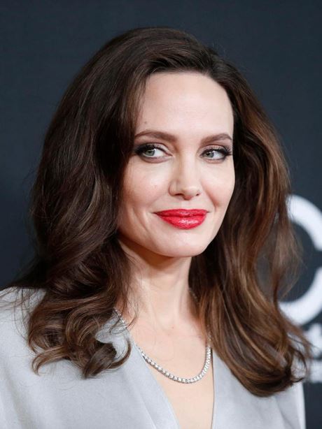 Angelina trang điểm khá nhẹ nhàng, tự nhiên, nhấn ở đôi môi mọng đỏ gợi cảm. Nữ diễn viên tạo dáng trên thảm đỏ bên ngoài sự kiện.