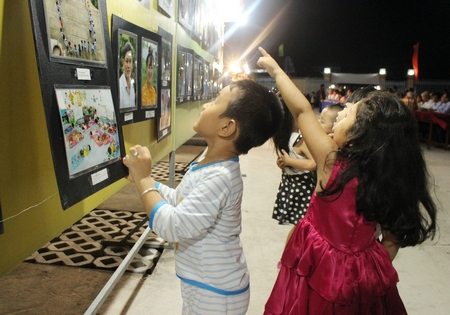 Các em nhỏ cũng háo hức đến xem triển lãm tranh ảnh.