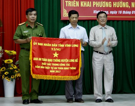 Ông Trần Hoàng Tựu- Phó Chủ tịch UBND tỉnh trao cờ xuất sắc cho Ban ATGT huyện Long Hồ.