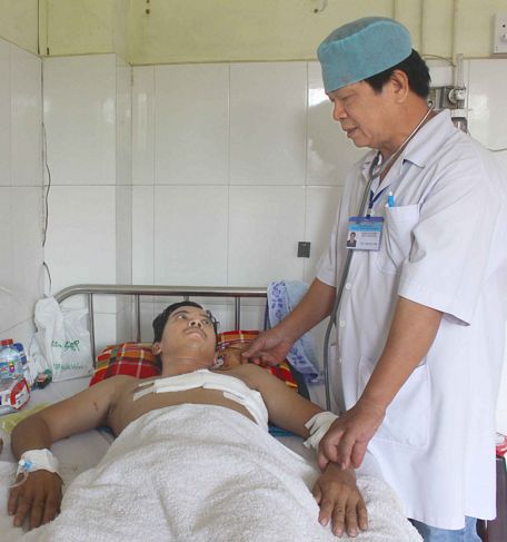 Bác sĩ Trần Văn Nhiều thăm khám bệnh nhân Hoàng Minh sau hơn tuần vào viện với vết thương tim, giờ trong tình trạng khỏe hẳn. Ảnh: MINH THÁI