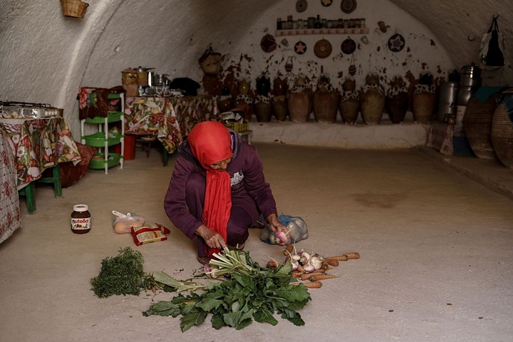 Mỗi một hang động là một gian phòng khác nhau với chức năng khác nhau. Cô Latifa Ben Yahia, 38 tuổi, đang chuẩn bị bữa trưa trong nhà bếp - Ảnh: REUTERS