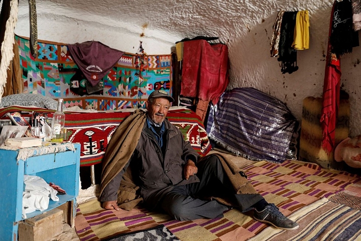 Ông Tayeb, 76 tuổi, ngồi bên trong ngôi nhà dưới lòng đất của mình. 